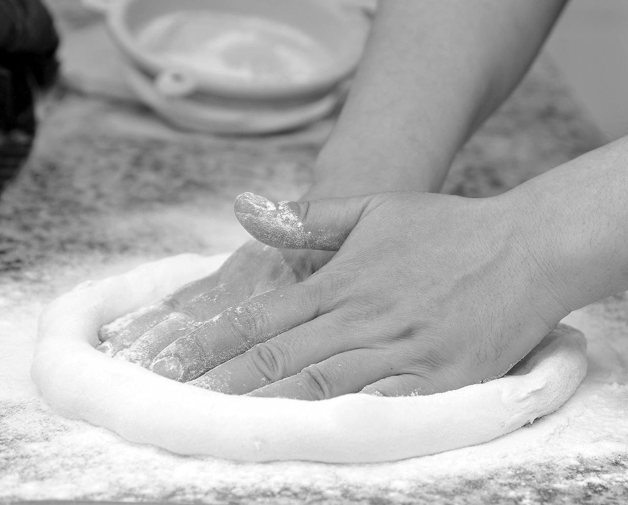 Hands kneading dough on a floured surface, perfect for baking themes.